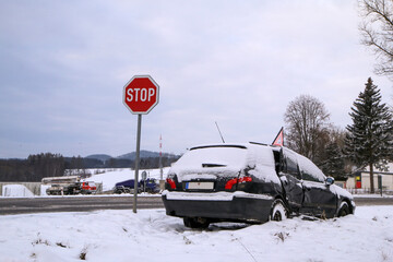 Fototapeta premium Abandoned car in the ditch after the traffic accident. The driver didn´t give way to another car. Covered by snow. 