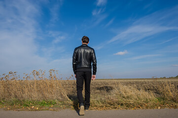 man walks in a field on a sunny day.