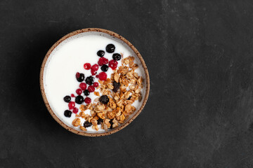 Homemade granola breakfast bowl with natural yogurt, berries, hazelnut and almond. Top view. Copy space.