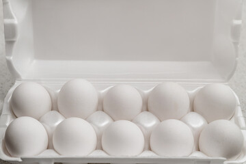 lots of white chicken eggs in a box on a white background copy space
