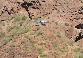 View of a hiker being airlifted from a dangerous situation on Camelback Mountain using a Phoenix Police helicopter in Arizona