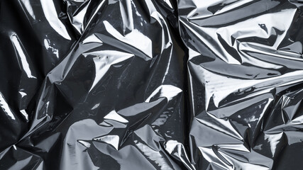 Smooth plastic texture. Black shiny film bag pattern. Wrap transparent dark cellophane background...