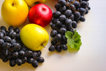 Fall fruits still life. Grapes and apples on a light background with room for copying