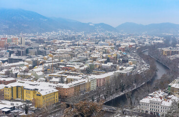 Obraz premium Cityscape of Graz with Mur river and historic buildings rooftops in winter with snow, in Graz, Styria region, Austria