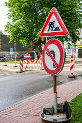 temporary post with warning and prohibition signs during street repairs