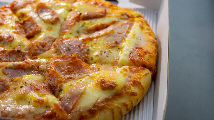 Sausage and Ham Cheese Pizza. The pizza in the daylivery box was delivered on the marble table top.