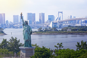 Statue of Liberty on Tokyo Bay in Japan with the Rainbow Bridge and skyscrapers in the background