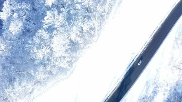 Drone flies around the road in winter in the mountains