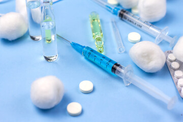 Syringes, ampoules and medical masks on a blue background. Antiviral vaccination. Medical background.