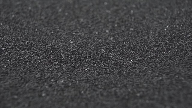 Black synthetic foam. Macro shot. Abstract background. Rotation