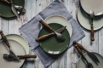 Gedeckter Tisch mit leerem Besteck und Tellern