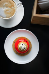 red strawberry cheesecake stuffed with cappuccino on a black table