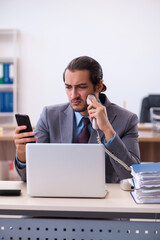 Fototapeta premium Young male employee unhappy with excessive work in the office