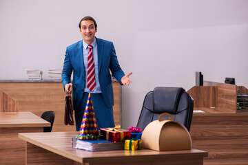 Young male employee celebrating Christmas at workplace