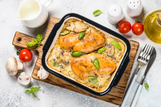 Baked chicken breast with mushrooms in cream sauce. Top view image with ingredients for cooking.