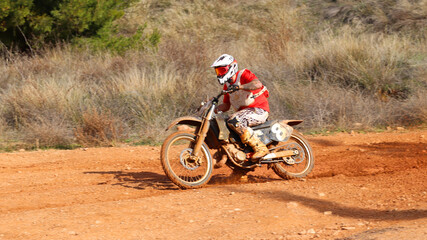 Professional dirt bike motocross rider performing stunts in extreme mud terrain track