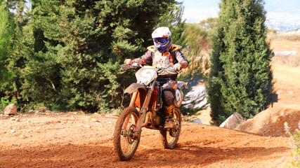 Professional dirt bike motocross rider performing stunts in extreme terrain track