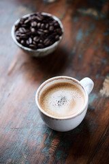 Cup of coffee on rustic wooden background. Close up.