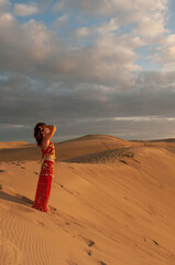 Arab belly dancer in the desert at sunset