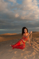 Fototapeta na wymiar Arab belly dancer in the desert at sunset