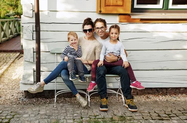 Foto op Aluminium Fine portrait of a cheerful family posing in front of the house © konradbak
