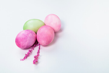Multi-colored eggs with twigs, on a white background with a place for text.
