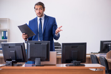 Young male employee in multitasking concept