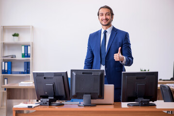 Young male employee in multitasking concept