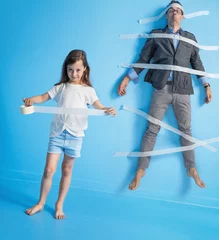 Foto op Canvas Funny portrait of a father being stuck to the wall by daughter © konradbak
