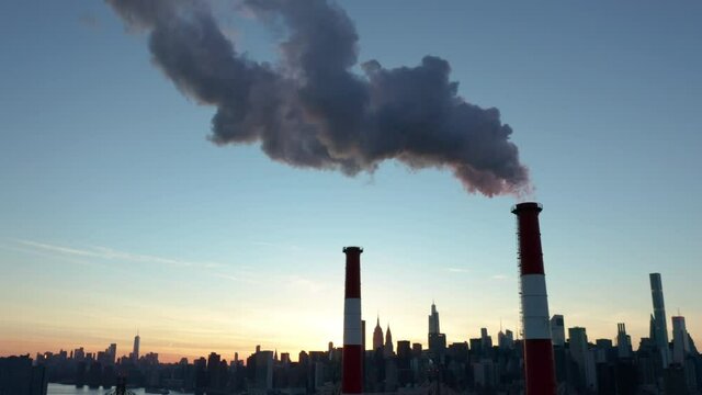 alt sunset flying backward and tilting down from LIC smokestack to reveal NYC