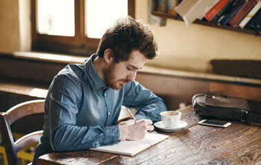 Young hipster man sketching in his studio