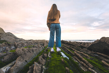 Young caucasian woman at the flysch geopark at the Basque Country.