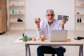 Old male dentist in expensive medicine concept