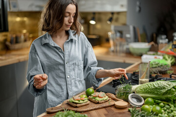 Beautiful woman with healthy green food in kitchen