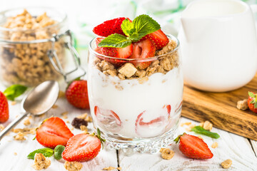 Greek yogurt with fresh strawberry and granola in glass jar. Parfait.