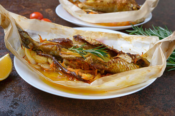 Fish with vegetables. Whole herring with lemon, onion, carrot and rosemary baked in the form of a boat.