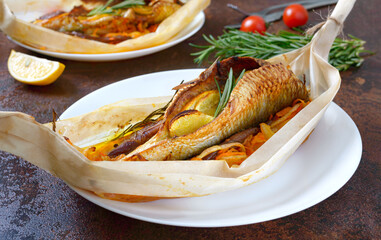 Fish with vegetables. Whole herring with lemon, onion, carrot and rosemary baked in the form of a boat.