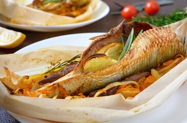 Fish with vegetables. Whole herring with lemon, onion, carrot and rosemary baked in the form of a boat. Close up