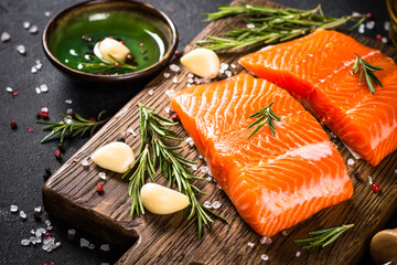 Fresh fish. Raw salmon fillet at cutting board with ingredients for cooking.