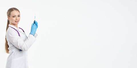 A young nurse in a mask and white coat holds a syringe with a needle for injections, flu shots, covid. The concept of vaccination and protection against influenza, from a pandemic. copy space. banner