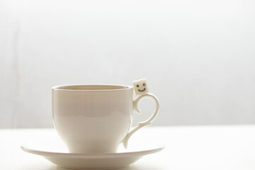 White sugar cube on cup of coffee. Smile. Concept.