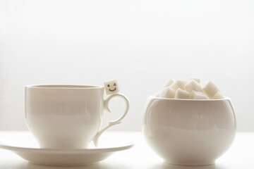White sugar cube on cup of coffee. Smile. Concept.