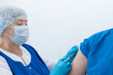 elderly nurse gives injection, vaccinatio