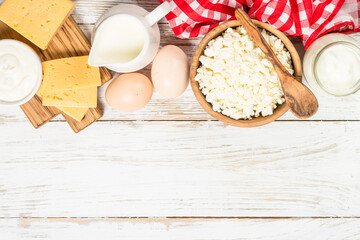 Dairy product at white wooden table. Curd, milk, yogurt, cheese and eggs. Organic farmer food. Top view with copy space.