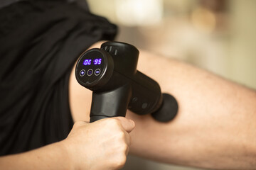 Man massaging leg with massage percussion device.