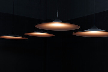 Modern pendant decorative lamps against black wall. Interior decoration of stylish office