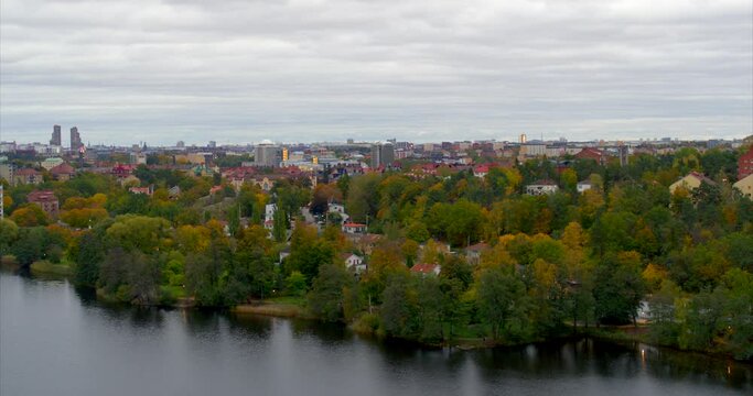 Flying over lake  with city suburb on the background, Sweden