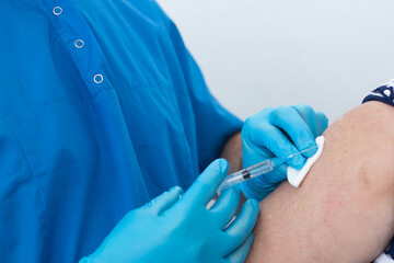 male nurse gives an injection to an elderly woman, vaccination