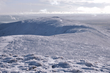 view of snow covered mountain with a sole hill walker