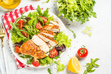 Grilled chicken with green salad. Keto diet, healthy eating. Top view on white table with space for text.